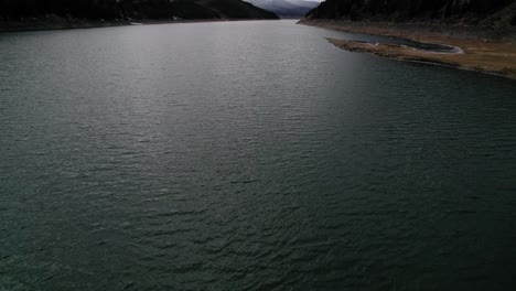 Drone-Aerial-View-Flying-Over-Dark-Moody-Body-Of-Water-During-A-Cloudy-Day-With-Dramatic-Light-Near-Sapphire-Point-Dillon-Reservoir-Colorado