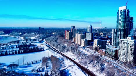 Aerial-winter-twist-overlooking-snow-covered-frozen-over-trees-rivers-edge-Victoria-park-at-the-most-lucrative-realty-properties-in-downtown-Edmonton-West-Side-100-Ave-above-Victoria-Park-Road-NW-L1-2