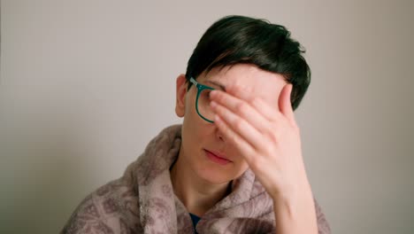 Close-up-view-of-a-women-wearing-glasses-checking-her-forehead-for-illness-symptoms