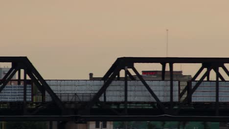 Panning-following-train-across-truss-bridge-over-river