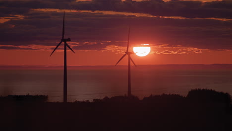 Wind-turbines-silhouette-producing-green-energy-at-red-sunset