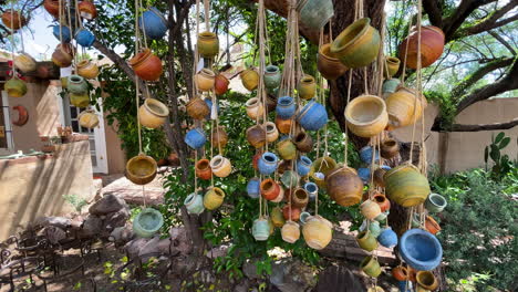 Colorful-terracotta-pots-hang-from-a-tree-on-strings