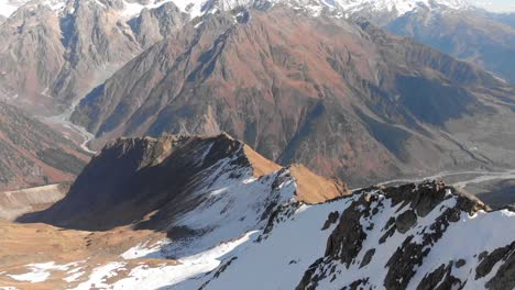 Volando-Pasó-Un-Pico-De-Montaña-Cubierto-De-Nieve-Para-Revelar-Un-Hermoso-Valle-De-La-Cordillera-En-Georgia