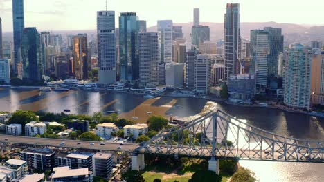 Vehicles-Travelling-Across-Story-Bridge-Over-Brisbane-River-At-Sunset-With-High-Rise-Buildings-At-Brisbane-CBD,-Queensland,-Australia