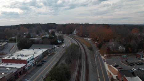 aerial-of-small-town-railroad-tracks-at-sunset-during-the-fall