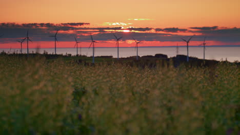 Granja-De-Turbinas-Eólicas-Que-Produce-Energía-Verde-Frente-A-La-Puesta-De-Sol-Del-Cielo-Del-Fuego