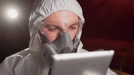 Mann-In-Schutzanzug-Und-Maske,-Der-Sich-Ein-Nachrichtenvideo-über-Die-Epidemie-Auf-Dem-Tablet-Ansieht