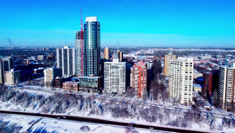 Aerial-reverse-drift-of-Edmonton's-most-lucrative-high-rise-homes-during-extreme-winter-cold-weather-snow-covering-Victoria-Park-cliff-road-on-100-Ave-NW-on-a-sunny-clear-sky-as-city-development-L2-2