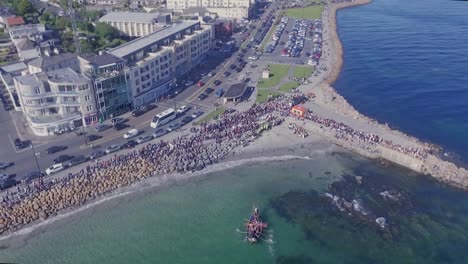 Aerial-Shot-of-Vikings-Rowing-to-and-Landing-on-Salthill-Beach,-Galway,-Top-Down