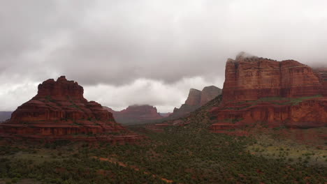 Landschaftsansicht-Von-Roten-Felsformationen-Mit-Dicken-Weißen-Wolken-Auf-Dem-Gipfel-In-Sedona,-Arizona,-Usa---Luftdrohnenaufnahme