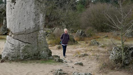 Eine-Einsame-Frau-Geht-Zwischen-Riesigen-Alten-Felsformationen-Pobiti-Kamani-Spazieren
