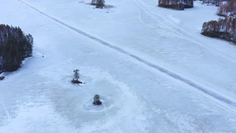 Aerial-drone-shot-of-straight-ice-road-on-an-icy-lake