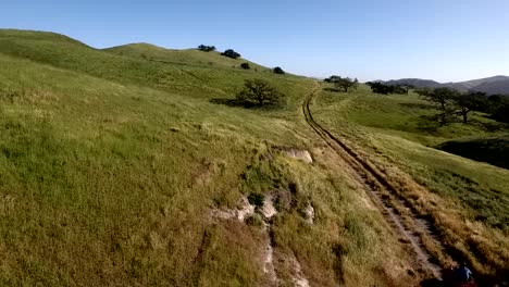 ATV-Speeding-Through-Muddy-Trail-Through-Green-Rolling-Hills