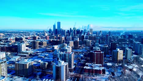 aerial-drone-reverse-aerial-flight-flyover-from-winter-capitol-city-of-Edmonton-snow-covered-as-most-building-are-steaming-thru-chimney's-smoke-during-extreme-cold-weather-skyline-skyscraper-view1-2