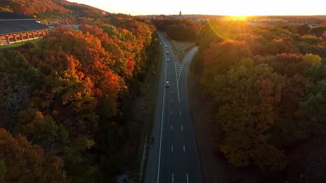 Aerial-establishing-shot-of-traffic-on-highway-road-during-gorgeous-fall-foliage-autumn-season