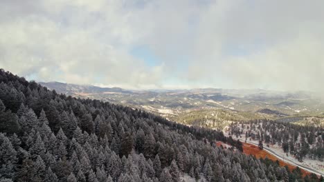 Drohnen-Luftaufnahme,-Die-über-Winterliche,-Schneebedeckte-Kiefernhanglandschaften-Und-Bergketten-In-Der-Nähe-Von-Kittredge-Evergreen-Colorado-Fliegt