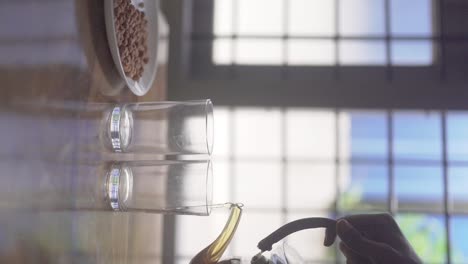 Female-Hand-Pours-Hot-Black-Coffee-Into-Two-Glasses-and-Peanuts-Served-in-Plate-|-VERTICAL-VIDEO