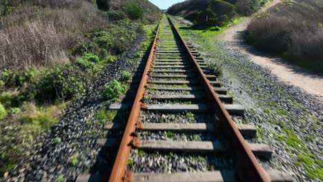 Fast-sweeping-shot-over-abandoned-rail-road-tracks,-Shark-Fin-Cove-California