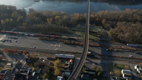 Aerial-View-of-Freight-Train-on-Baltimore-Ohio-Railroad-by-Brunswick-and-Potomac-River,-Maryland-on-Sunny-Autumn-Day,-Drone-Shot