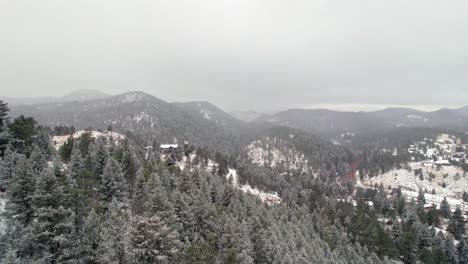 Drohne-Luftbild-Fliegen-über-Schneebedeckte-Kiefernhügel-Und-Berge-Winterlandschaft-In-Der-Nähe-Von-Kittredge-Evergreen-Colorado
