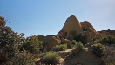 The-Amazing-Skull-Rock-Formation-At-Joshua-Tree-National-Park-In-California-Under-The-Clear-Blue-Sky---Panning-Shot