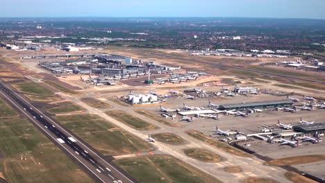 Vista-Aérea-Del-Aeropuerto-Heathrow-De-Londres-Sobre-La-Pista-09l-Hasta-La-Torre-De-Control-Y-Las-Terminales-1,-2-Y-3