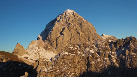Rotating-cinematic-aerial-shot-of-the-sun-on-the-Mangart-mountain-in-the-Julian-alps-in-Slovenia