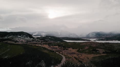 Cloudy-Moody-Drone-Aerial-View-Of-Winter-Hills-And-Mountain-Range-Near-Swan-Mountain-Road-And-Snake-River-Arm-In-Sapphire-Point-Dillon-Reservoir,-Colorado
