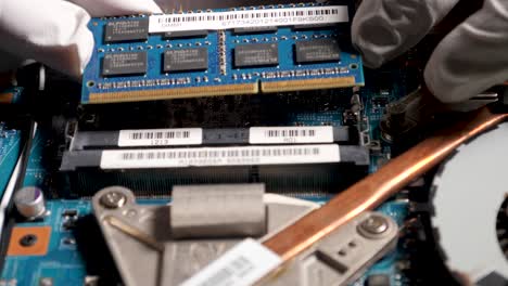 Computer-Technician-Installing-More-RAM-To-Laptop-In-Computer-Repair-Shop,-DDR4-RAM-Memory-Slot,-4K-UHD-Footage-Of-Latino-Man-Hand-Installing-Laptop-RAM-Module