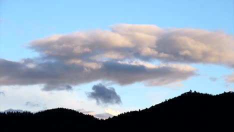 Clouds-move-over-silhouette-mountains,-timelapse