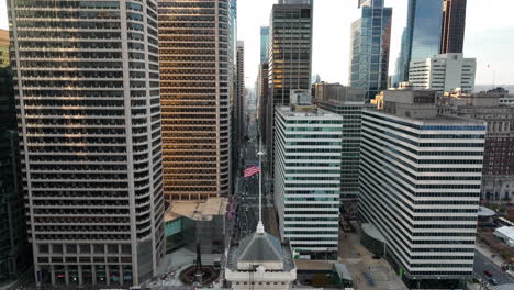 Aerial-of-American-flag-in-downtown-urban-city-in-USA