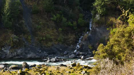 Wide-Pan-Shot-Cascade-Flowing-into-River