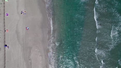 Top-down-aerial-view-of-tourists-enjoying-their-beach-holiday-in-La-Grande-Motte,-France