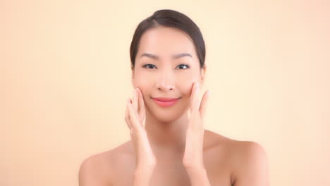 Eine-Junge-Schöne-Asiatin-Massiert-Ihr-Gesicht-Sanft-Mit-Den-Fingerspitzen