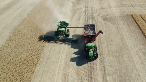 Combine-Tractors-Harvesting-Crops-On-Sunny-Day-In-Saskatchewan,-Canada