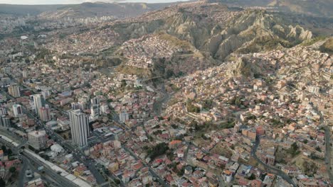 Aerial-Establishing-Shot-of-La-Paz-City,-Bolivia,-Slum-Houses-on-Andean-Mountain-with-Sunlight,-Latin-American-Travel-Destination