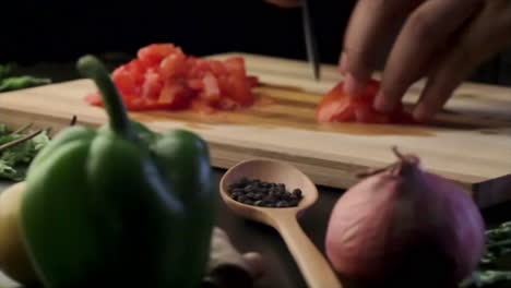 Picar-Tomate-En-Una-Tabla-De-Cortar-De-Madera-Con-Un-Cuchillo-Afilado-En-La-Cocina,-Cortar-Verduras
