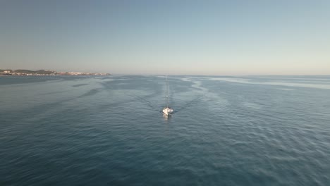 Aerial-view-of-yacht-cruising-peaceful-Spanish-seascape-coastline-aerial-orbit-passing-right