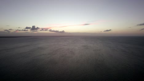 Aerial-shot-of-the-sun-setting-over-the-vast-ocean