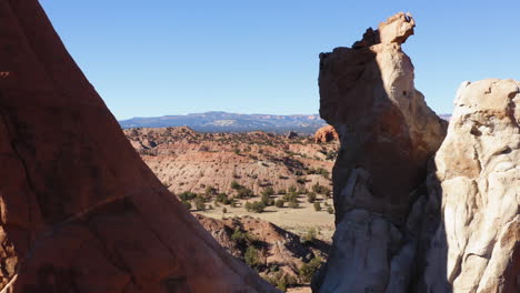 Drone-flies-between-rocks-in-a-desert-and-rocky-landscape