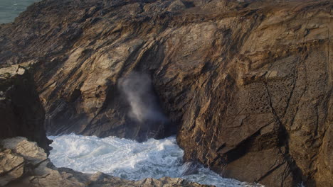 Slow-Motion-Of-Waves-Crashing-Through-Dramatic-Blowhole-In-Porth-Island,-Newquay,-Cornwall,-UK