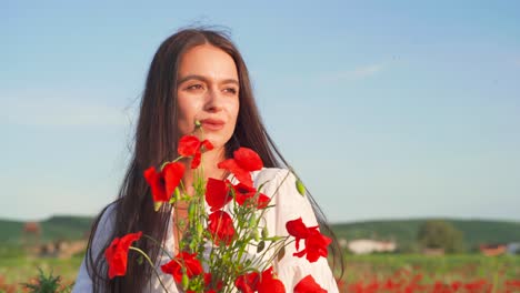 Die-Kaukasische-Frau-Hält-An-Einem-Sonnigen-Tag-Leuchtend-Bunte-Rote-Wilde-Mohnblumen-Und-Riecht-An-Blütenblättern,-Nahaufnahmeporträt