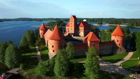 Trakai-Island-Castle-Surrounded-With-Green-Lush-Trees-On-Sunny-Day-In-Trakai,-Lithuania