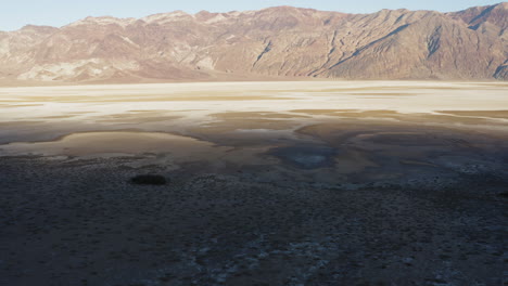 Lufttrockene-Wüstenlandschaft-Mit-Blick-Auf-Die-Auswandererschlucht,-Drohnenfliege-über-Dem-Badwater-Becken,-Einem-Endorheic-Becken-Im-Death-Valley-Nationalpark,-Während-Eines-Heißen-Sonnigen-Tages,-Das-Ein-Erstaunliches-Unerforschtes-Gebiet-Enthüllt