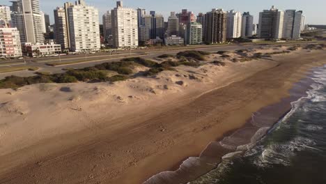 Eine-Drohne-Schwenkt-Bei-Sonnenaufgang-In-Punta-Del-Este-über-Den-Strand