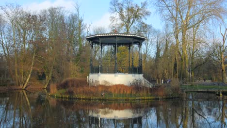Vondelpark-in-Amsterdam,-with-famous-hut-on-a-small-island-surrounded-by-a-pond-during-fall