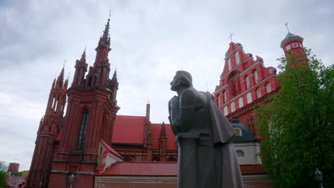 Estatua-De-Adam-Mickiewicz,-Iglesia-De-Santa-Ana-E-Iglesia-De-Bernardina-En-El-Casco-Antiguo-De-Vilnius-En-Lituania---Toma-Panorámica-Inclinada-Hacia-Arriba