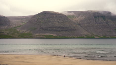 Niña-Recogiendo-Conchas-En-La-Playa-Islandesa-De-Arena