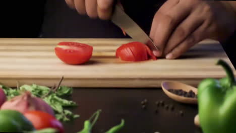 chopping-tomato-on-a-wooden-chopping-board-with-a-sharp-knife-in-the-kitchen,-cutting-vegetables