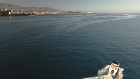 Aerial-view-over-tourists-boat-cruising-Spanish-Calahonda-seascape-coastline